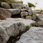 Enrochement jardin : pierres de granit et talus stabilisé