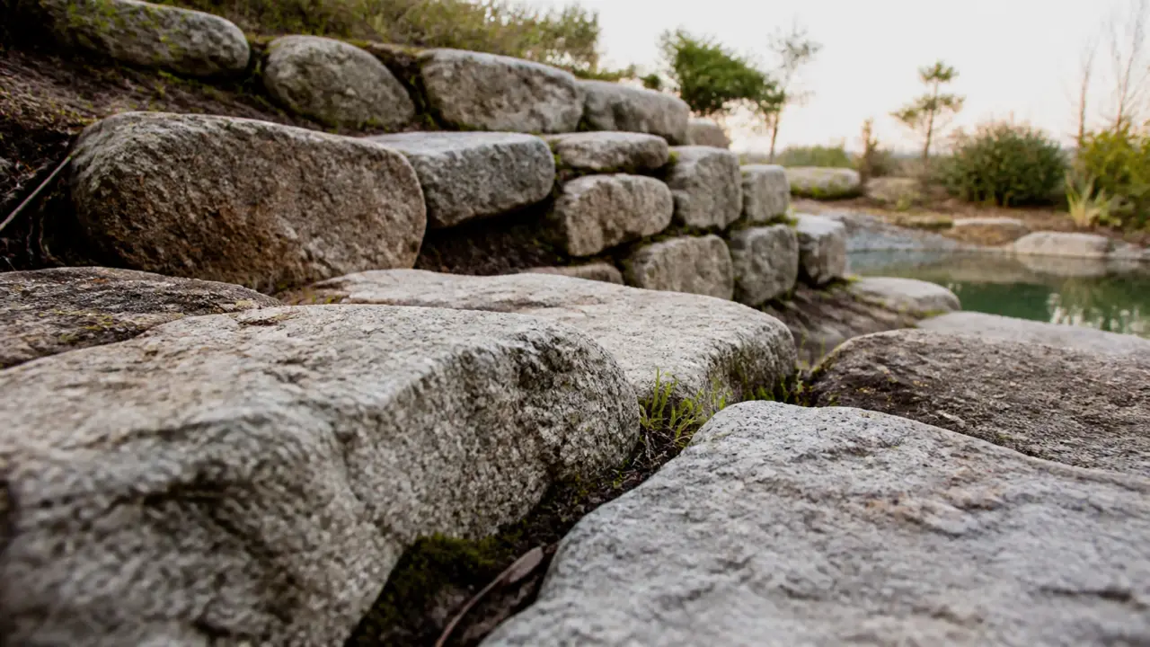 Enrochement jardin : pierres de granit et talus stabilisé