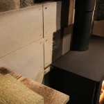 Habillage mur derriere un poele a bois avec panneaux anti-rayonnement en silicate de calcium et laine de roche
